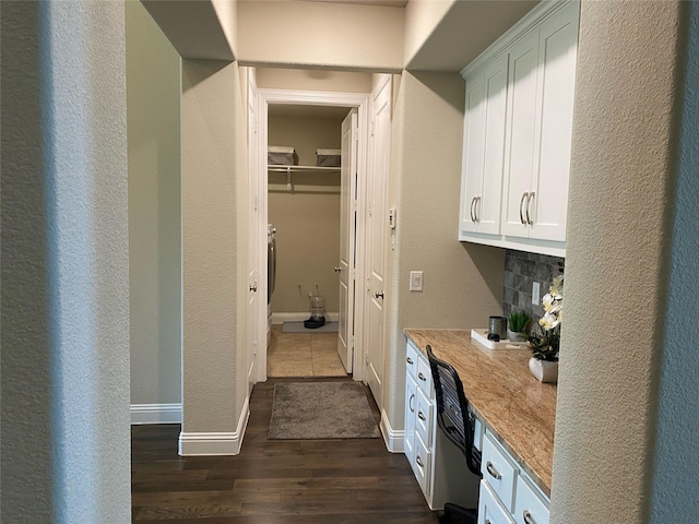 interior space featuring dark wood-type flooring and baseboards