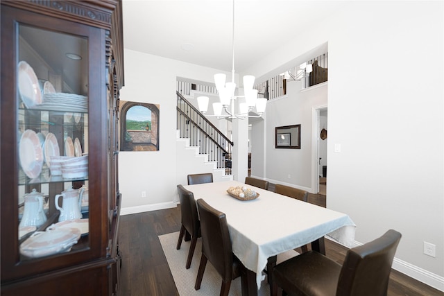 dining space featuring dark wood-type flooring, baseboards, and a notable chandelier