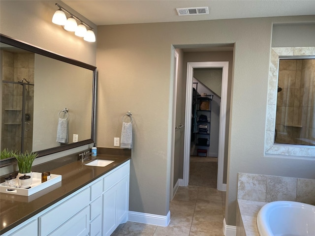 bathroom featuring visible vents, a stall shower, tile patterned flooring, baseboards, and vanity