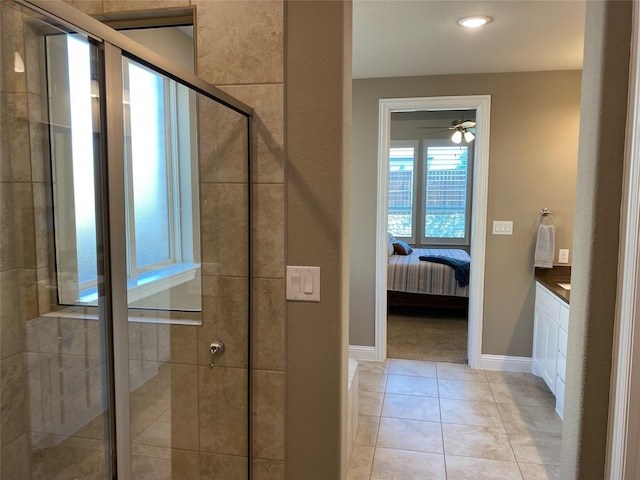 ensuite bathroom featuring a shower stall, baseboards, ceiling fan, tile patterned floors, and ensuite bath