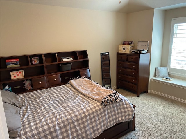 bedroom featuring light colored carpet and baseboards