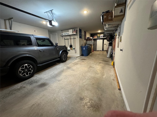 garage with a garage door opener and baseboards