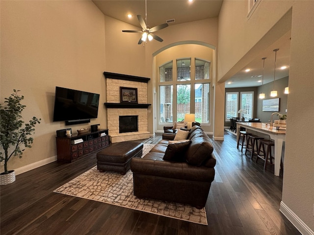 living room featuring baseboards, visible vents, dark wood-style flooring, and ceiling fan