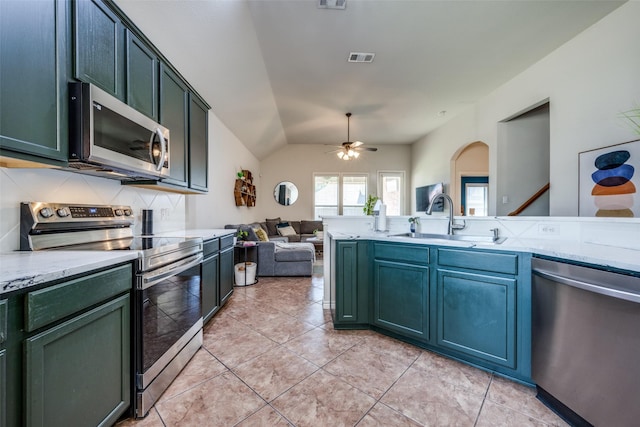 kitchen featuring visible vents, a sink, open floor plan, appliances with stainless steel finishes, and tasteful backsplash