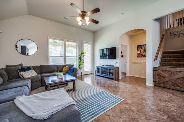 tiled living room with stairway, baseboards, arched walkways, ceiling fan, and vaulted ceiling