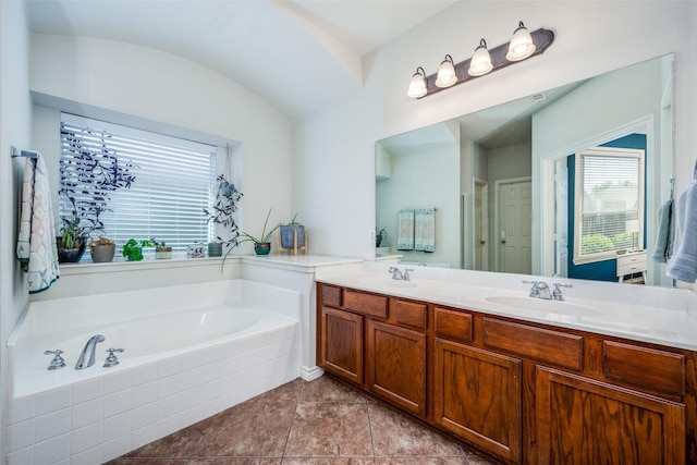 full bath featuring a sink, a bath, double vanity, and tile patterned flooring