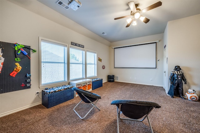 cinema room featuring visible vents, baseboards, ceiling fan, and carpet flooring