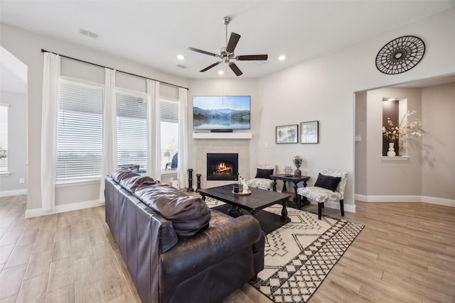 living area with light wood-type flooring, visible vents, a ceiling fan, recessed lighting, and a tile fireplace