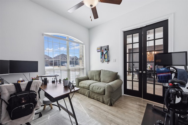 home office featuring french doors, light wood-style flooring, and a ceiling fan