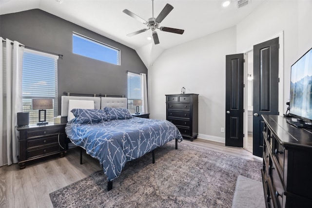 bedroom with visible vents, baseboards, wood finished floors, and vaulted ceiling