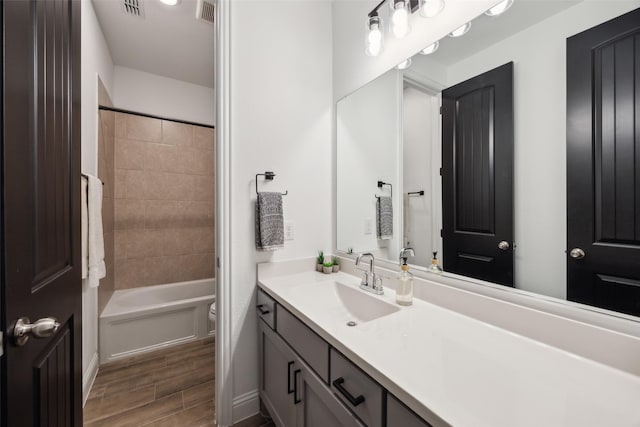 full bathroom with visible vents, toilet, vanity, and wood finish floors