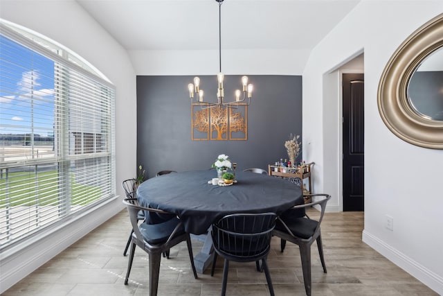 dining area with baseboards, an inviting chandelier, and wood finished floors