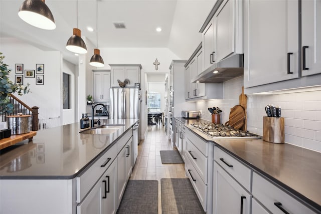 kitchen with visible vents, under cabinet range hood, a sink, dark countertops, and stainless steel appliances