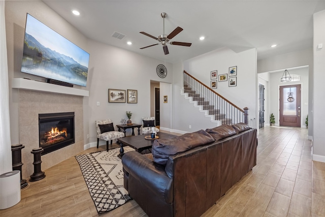 living area with stairway, visible vents, light wood-style flooring, recessed lighting, and a fireplace