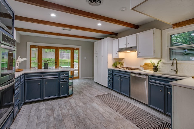 1311 Cedar Hill Ave, Dallas, TX 75208 - kitchen with blue cabinetry, stainless steel appliances, white cabinets, beamed ceiling, and light countertops