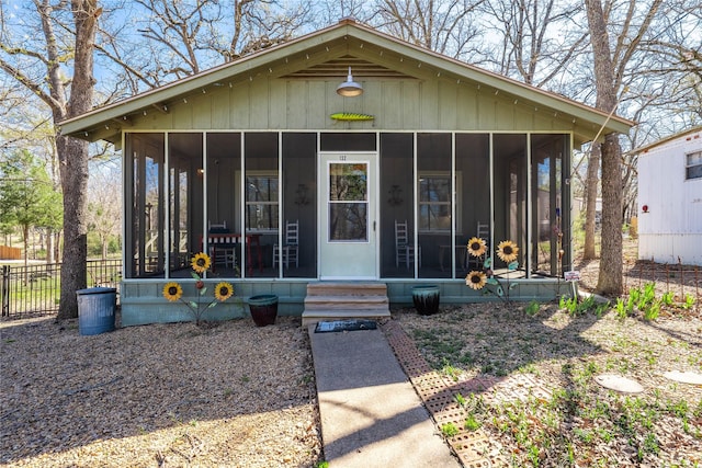 view of front of home featuring fence and a sunroom