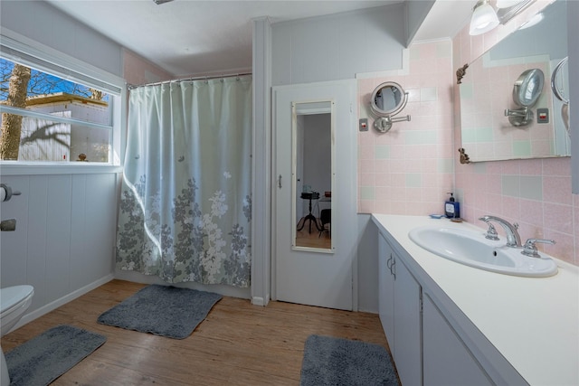 full bath featuring vanity, decorative backsplash, curtained shower, and wood finished floors