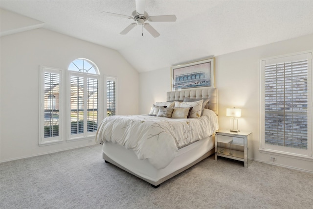 bedroom featuring a ceiling fan, baseboards, lofted ceiling, a textured ceiling, and carpet flooring