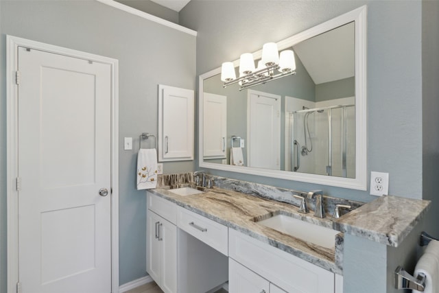 full bathroom with a sink, a stall shower, and double vanity