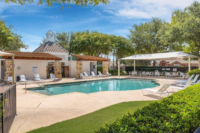 pool with a patio and fence