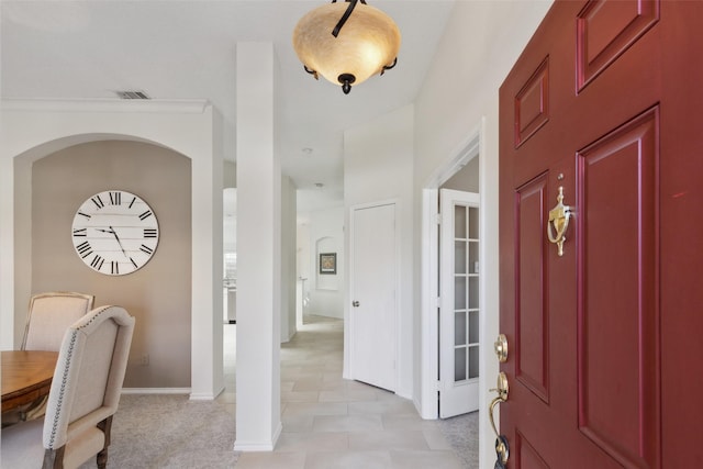 foyer featuring baseboards and visible vents