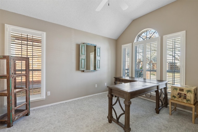 carpeted home office with lofted ceiling, a ceiling fan, baseboards, and a textured ceiling