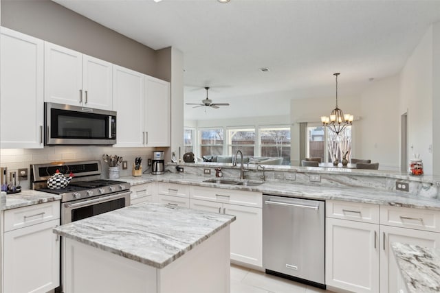 kitchen featuring tasteful backsplash, appliances with stainless steel finishes, white cabinetry, and a sink