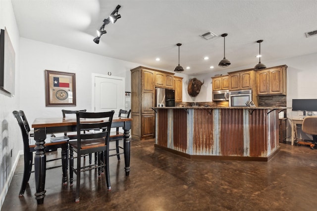 kitchen with finished concrete floors, visible vents, a kitchen bar, and stainless steel appliances