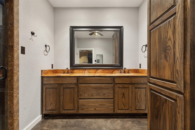 full bathroom featuring double vanity, a textured wall, and a sink