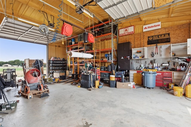 garage with a workshop area, a garage door opener, and metal wall