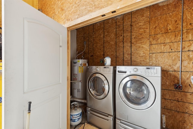 clothes washing area with laundry area, washer and dryer, and electric water heater