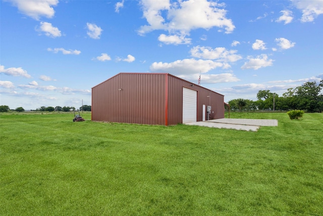 view of pole building with driveway and a yard