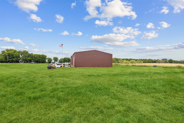 view of yard featuring an outbuilding, an outdoor structure, and a rural view