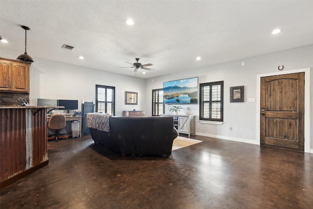 living area featuring visible vents, a textured ceiling, finished concrete floors, recessed lighting, and ceiling fan