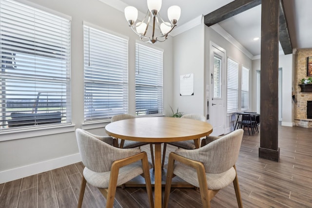 dining space with baseboards, an inviting chandelier, wood tiled floor, and crown molding