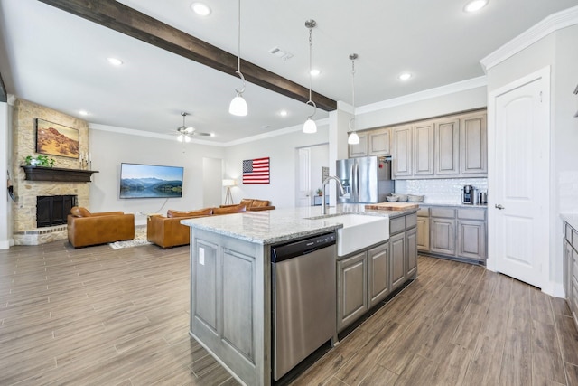 kitchen featuring visible vents, gray cabinetry, light wood-style floors, stainless steel appliances, and a sink