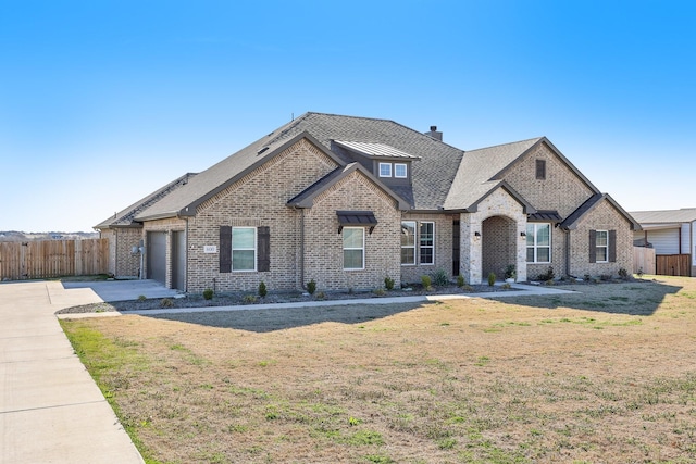 view of front of property featuring brick siding, driveway, a garage, and fence