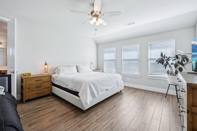 bedroom with visible vents, baseboards, lofted ceiling, and wood tiled floor