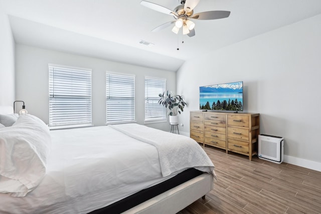 bedroom featuring visible vents, baseboards, wood finished floors, and a ceiling fan