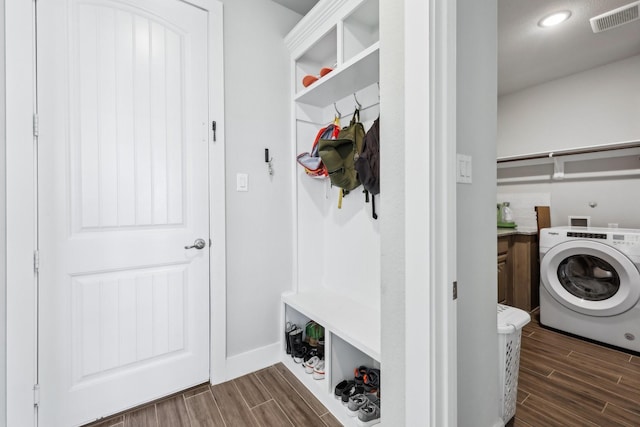 clothes washing area with wood finish floors, visible vents, washer / clothes dryer, and laundry area