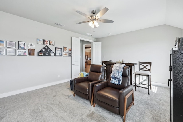 living area with visible vents, lofted ceiling, a ceiling fan, and carpet flooring