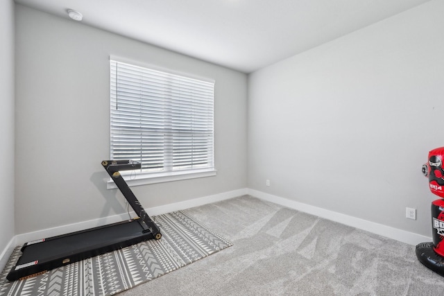 workout room featuring baseboards and carpet