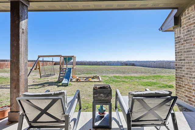 view of patio with a playground and fence