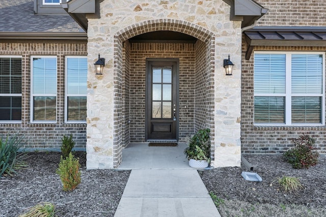 view of exterior entry with brick siding and stone siding