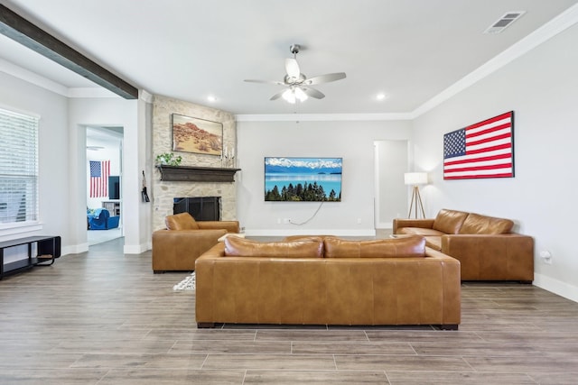 living room featuring a ceiling fan, visible vents, and ornamental molding