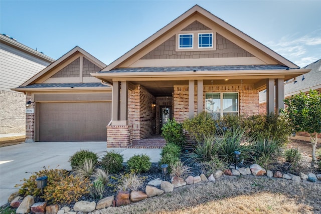 craftsman inspired home featuring brick siding, covered porch, concrete driveway, and an attached garage