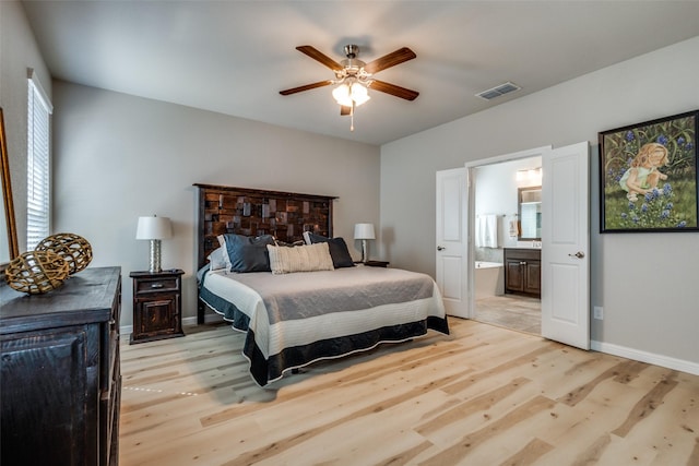 bedroom with baseboards, visible vents, ensuite bath, ceiling fan, and light wood-type flooring