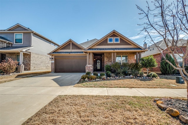 craftsman house with a garage, brick siding, and concrete driveway