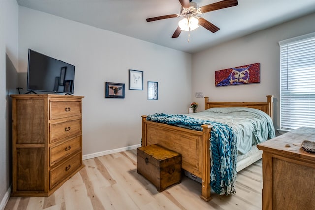 bedroom with baseboards, light wood-style flooring, and a ceiling fan