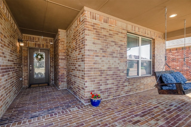 doorway to property featuring brick siding